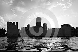 Italy - Sirmone castle silhouette on the Garda lake at sunset. Medieval architecture with tower