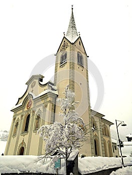 Italy, Trentino Alto Adige, Bolzano, San Vigilio di Marebbe, view of the church of the town during a winter day and during a snowf photo