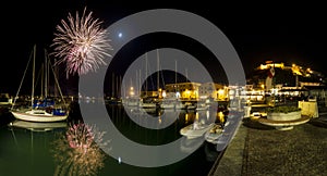 Italy, Tuscany Maremma Castiglione della Pescaia, fireworks over the sea, panoramic night view of the port and the castle