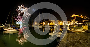 Italy, Tuscany Maremma Castiglione della Pescaia, fireworks over the sea, panoramic night view of the port and the castle
