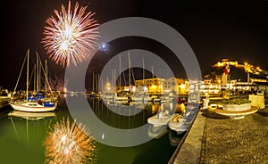 Italy, Tuscany Maremma Castiglione della Pescaia, fireworks over the sea, panoramic night view of the port and the castle