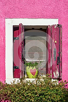 Italy, Venice, Burano island. Traditional colorful walls and windows of the old houses.