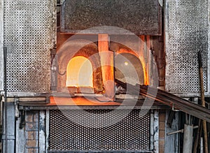 Italy, Venice, Murano glass factory special glass-blowing tools: red-hot furnace with fire to make the glass malleable, and iron