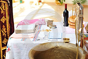 Items for christening ceremony on table in church.