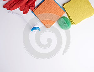 Items for home cleaning: red rubber gloves, brush, multi-colored sponges for dusting