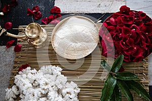 Items for the Indian Yajna ritual. garland of white flowers, red rose petals and copper dish with rice for Hindu Vedic Yajna