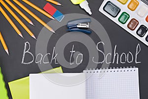 Items for school are on a blackboard with an inscription in chalk