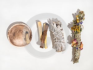 Items for spiritual cleansing - sage and aromatic herbs bundle and palo santo incense sticks on white background