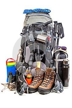 Items for tourism and hiking near a tourist backpack on a white background. set of equipment for tourism and travel