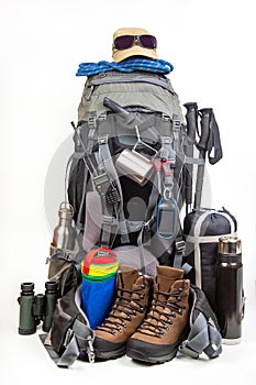 Items for tourism and hiking near a tourist backpack on a white background. set of equipment for tourism and travel