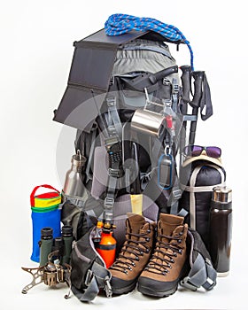 Items for tourism and hiking near a tourist backpack on a white background. set of equipment for tourism and travel
