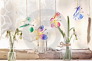 Iterior window with glass butterflies and snowdrops