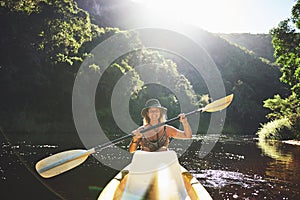 Itll be worth it, I promise. a young woman out kayaking on a lake.