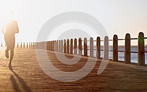 Its all about endurance. A young woman running along the promenade at sunset.