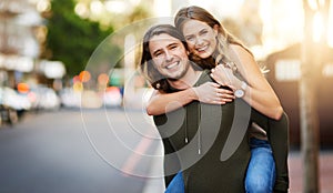 Its all fun and games when theyre together. Portrait of a happy young couple enjoying a piggyback ride in the city.