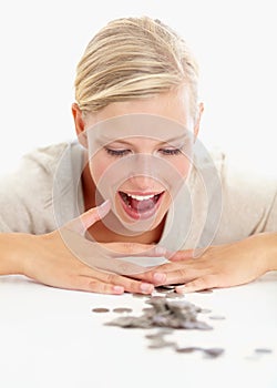 Its all mine. Shot of a beautiful woman looking at coins on the table in front of her.