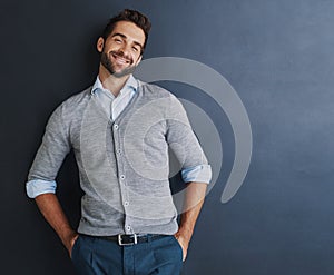 Its all about staying positive. Portrait of a handsome young businessman posing against a dark background.