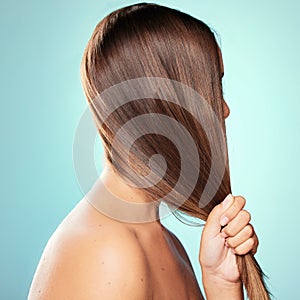 Its amazing to have frizz-free hair. Studio shot of an unrecognizable young woman posing against a blue background.