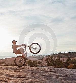 Its amazing where two wheels can take you. a young man out mountain biking during the day.