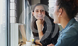 Its been a while since we had a chance to catchup. two young women chatting in a cafe.