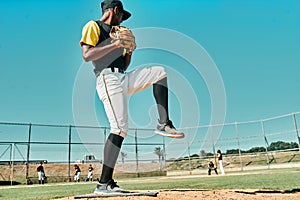 Its coming your way. shot of a young baseball player getting ready to pitch the ball during a game outdoors.