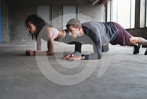 Its crunch time. Full length shot of a sporty young couple exercising together inside an underground parking lot.