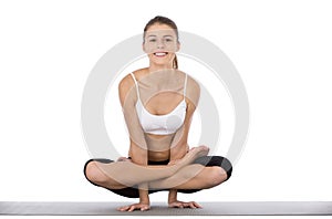 Its fun to be flexible. An attractive young woman working out against a white background.