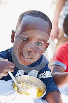 Its so good. Cropped portrait of a young boy getting fed at a food outreach.