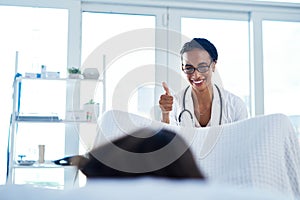 Its always a good idea to get checked. a young gynaecologist giving a thumbs up during a consultation with her patient. photo