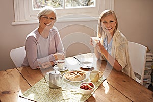 Its a great day for a tea party. an attractive young woman visiting her gran for tea.