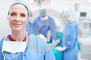 Its a great day to save lives. Portrait of a happy mature woman wearing hospital scrubs in an operating theatre during a