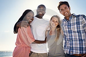 Its great spending time with close friends. Cropped portrait of two happy couples enjoying a day at the beach.