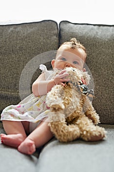 Its her favourite teddy. Portrait of an adorable baby girl playing with a teddybear at home.
