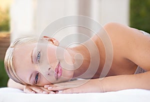 Its here that I let my worries wash away. A gorgeous blond woman looking at you while lying on a spa bed.