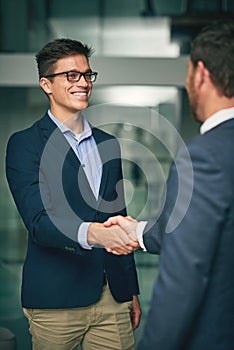 Its important to continually make new business contacts. two businessmen shaking hands in an office.