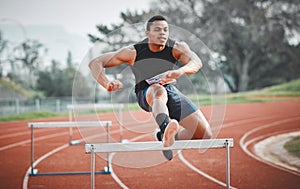 Its important to time your jumps correctly. Full length shot of a handsome young male athlete practicing hurdles on an