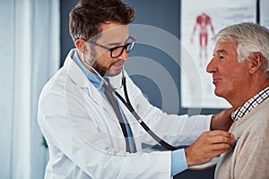 Its just a routine examination. a doctor examining a senior patient with a stethoscope in a clinic.