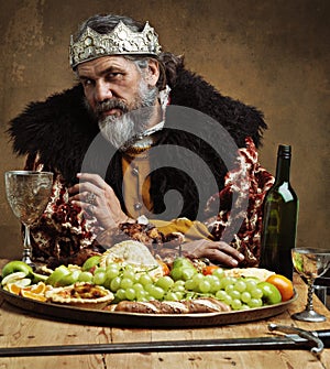 Its lonely at the top. A mature king feasting alone in a banquet hall.