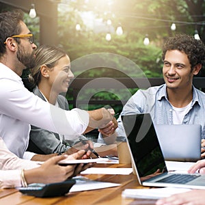 Its my pleasure to welcome you to our team. Shot of businesspeople shaking hands during a meeting at a cafe.