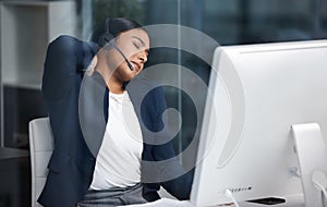 Its not good to be stuck at your desk all day. a young businesswoman experiencing neck pain while working in a call