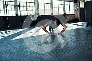 Its not about having time, its about making time. a young man doing push ups in a gym.