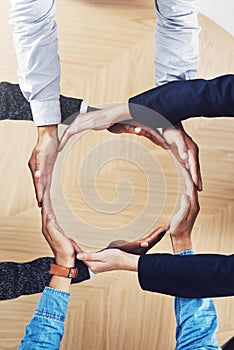 Its our world and were all living in it. High angle shot of a group of unidentifiable businesspeople forming a circle