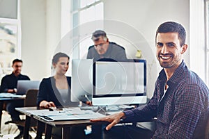 Its a pleasure to be part of a productive team. Portrait of young businessman using a computer at work with his