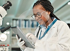 Its the quickest way to store and share data. a young scientist using a digital tablet in a lab.