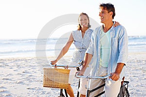 Its so refreshing to be outdoors. A mature couple enjoying a bike ride on the beach together.