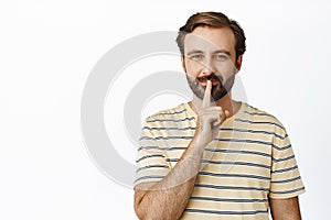 Its a secret. Smiling coy guy showing shush, taboo hush gesture, prepare surprise, looking mysterious, standing over