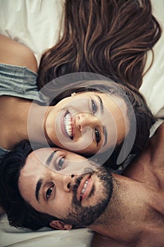 Its a stay in bed kinda day. High angle portrait of an affectionate young couple relaxing in bed.