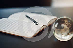 Its time to make a new plan. Still life shot of a notebook and pen on a table in an office.