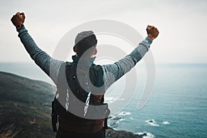 Its time to remember what its like to feel alive. Rearview shot of a young man standing with his arms outstretched while