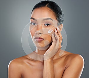 Its the only way I prevent breakouts. a beautiful young woman applying moisturiser to her face.